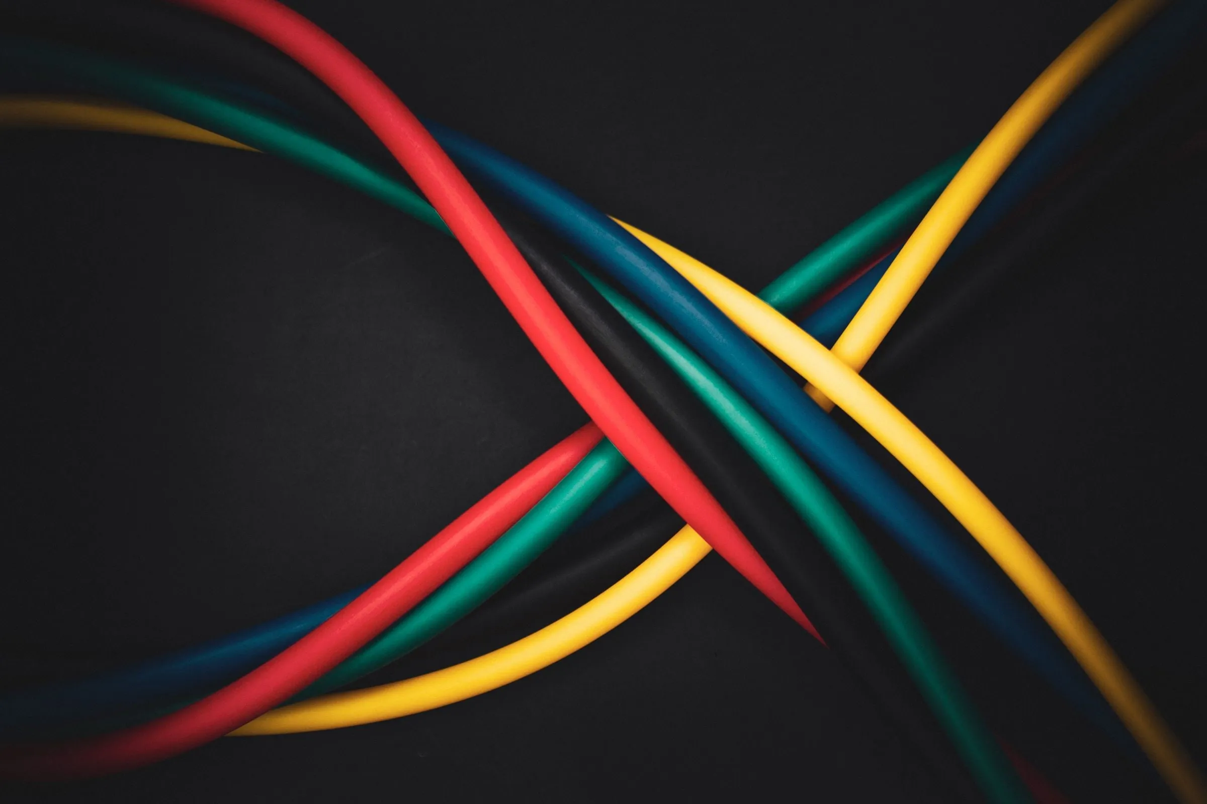 Insulated cables crossing against a dark ground