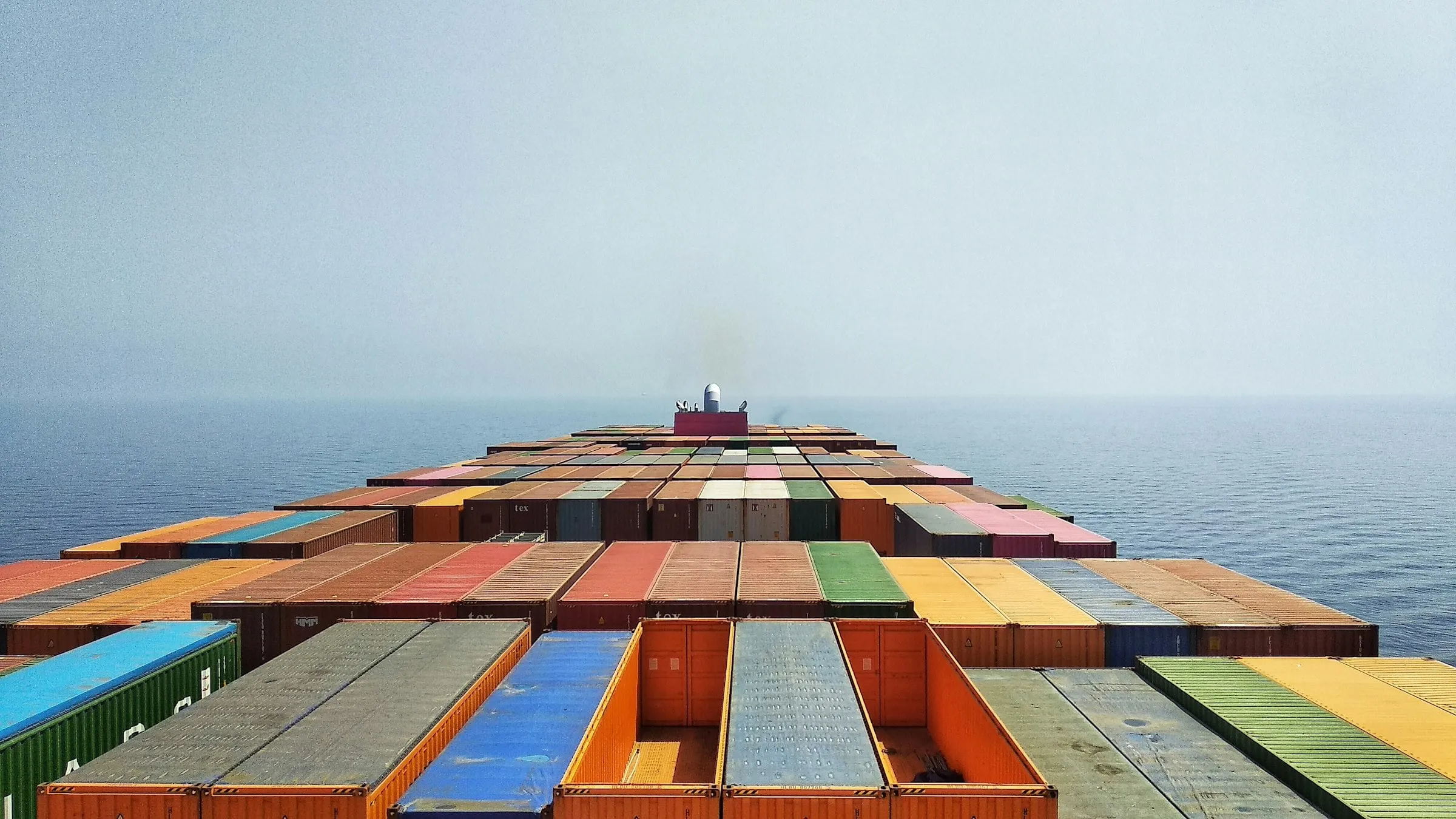 Loaded container deck of a cargo vessel looking forward into open sea